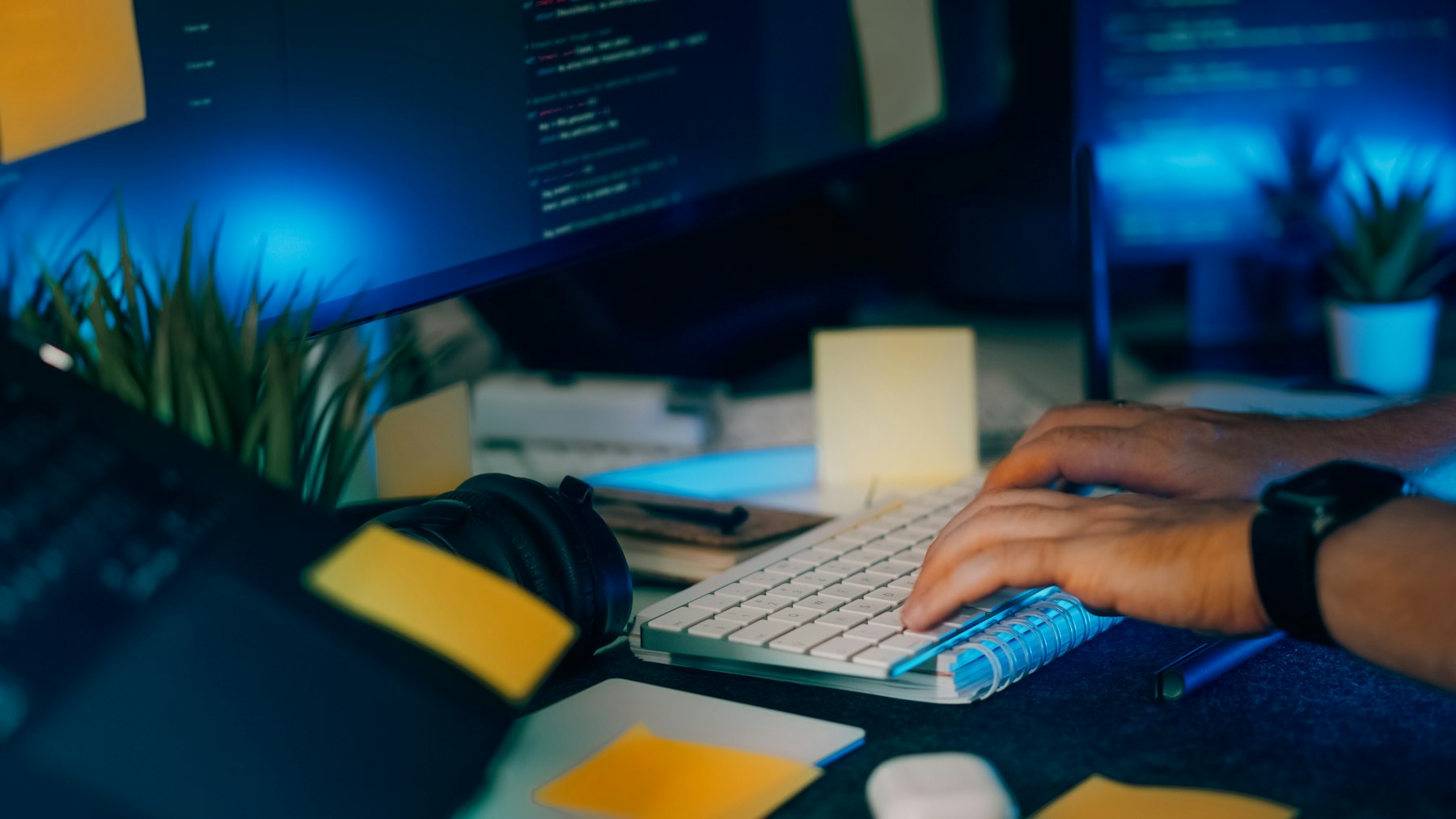 Close-up of hands typing while reviewing source code